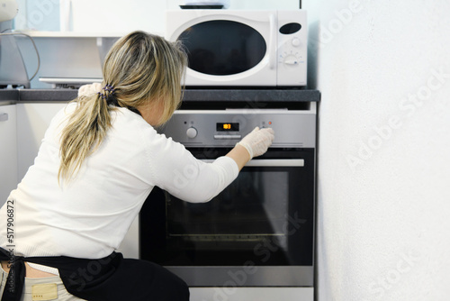 Woman cook sets the right temperature in the oven for baking.