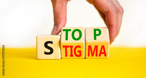 Stop stigma symbol. Concept words Stop stigma on wooden cubes. Businessman hand. Beautiful yellow table white background. Business and Stop stigma concept. Copy space.