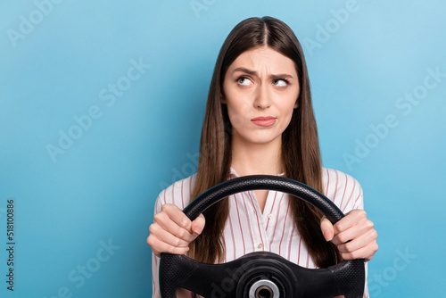 Portrait of attractive minded skeptic girl riding car thinking copy space isolated over shine blue color background