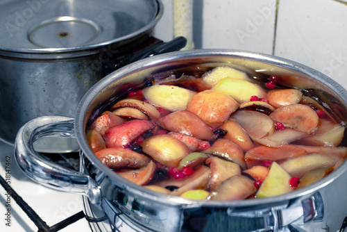 Fruit compote in a bowl. Fresh and tasty compote. Preparation of a healthy fruit compote in a chrome pan