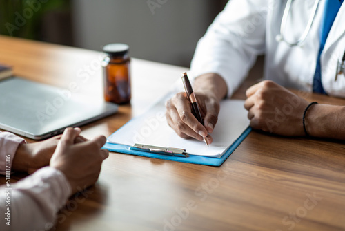 Unrecognizable doctor taking anamnesis of female patient