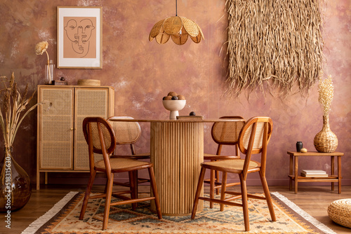 Stylish boho vintage dining room interior with poster mock up. Round table with rattan chair, commode and plants. Brown wall and rattan lamp. Mock up poster. Template.