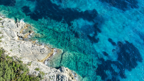 Aerial birds eye view photo taken by drone depicting beautiful deep blue turquoise waters and lovely rocky seascape in Greece
