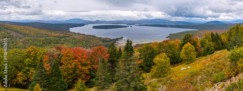 Height of Land - A panoramic overview of Mooselookmeguntic Lake and its surrounding rolling hills on a colorful but stormy Autumn day, as seen from Height of Land at side of Route 17, Maine, USA.