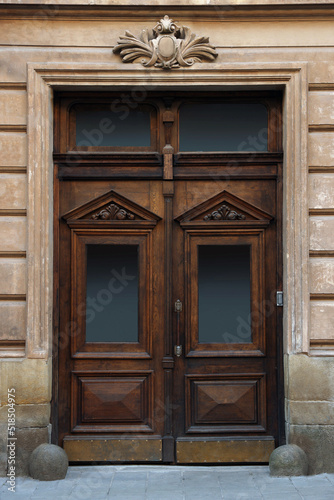 Entrance of house with beautiful wooden door, elegant molding and transom window
