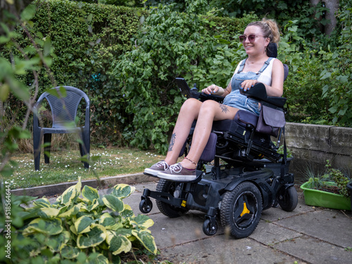 Woman in electric wheelchair in back yard