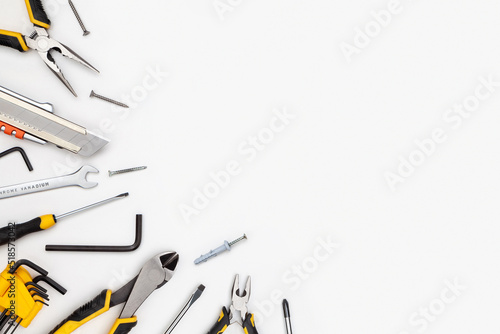 DIY Tool For Building Or Repairing On White Background. The Workplace Of The Foreman. Professional Repair And Construction Tool. Space For Text. Screwdriver, interchangeable nozzles, wrench, pliers.