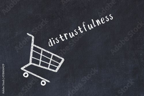 Chalk drawing of shopping cart and word distrustfulness on black chalboard. Concept of globalization and mass consuming