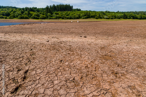 Baked, cracked, dry soil at a near empty reservoir during a heatwave and drought