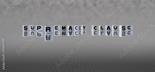 supremacy clause word or concept represented by black and white letter cubes on a grey horizon background stretching to infinity