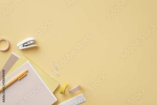 Back to school concept. Top view photo of stationery diaries pen ruler clips mini stapler and adhesive tape on isolated pastel yellow background with copyspace