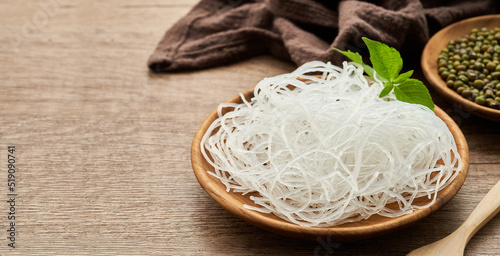 Asian vermicelli or cellophane noodle and mung green bean in wooden plate on wood table background. glass noodle 