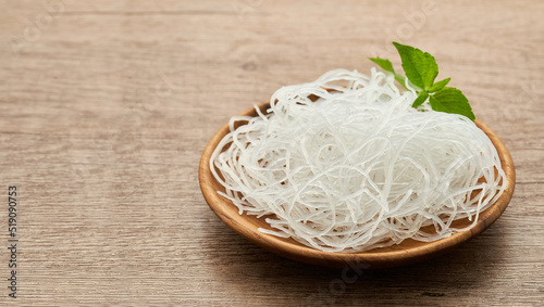 Asian vermicelli or cellophane noodle in wooden plate on wood table background. glass noodle 