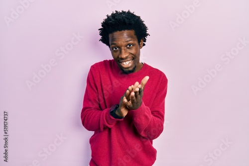 Young african american man wearing casual clothes clapping and applauding happy and joyful, smiling proud hands together