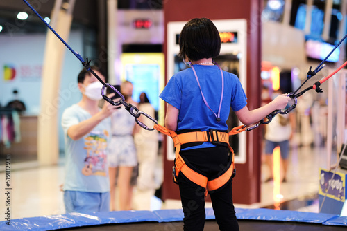 little boy climbing a rock wall indoor, Kid climbing the wall outdoors, Active leisure time with children concept, Little boy in a rope park.