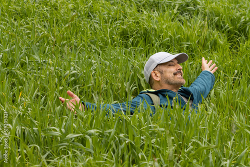 Happy man with open arms in a field in the middle of nature.