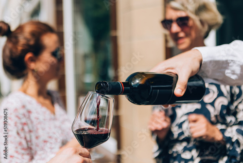 pouring red wine on glass at the aperitif happy hour wine tasting