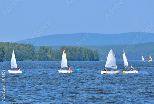 Youth sailing regatta on the pond on a summer day