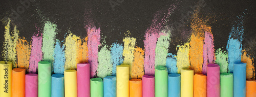 Multicolored chalk on black board. Back to school. Colored background. Banner