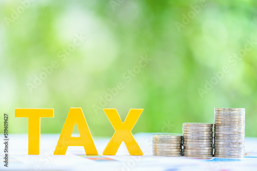 Personal income tax, pay self assessment tax bill, financial concept : Yellow wood alphabet letters TAX on a table, depicting a taxpayer computes and prepares to pay individual or personal income tax.