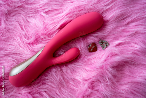 pink vibrator sex toy with hearts on pink background