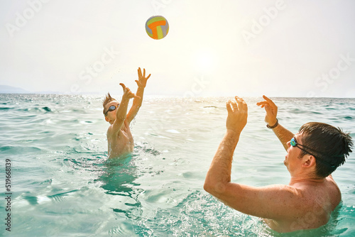 Happy family, father and son bonding, play ball, swim in the sea looking at view enjoying summer vacation. Togetherness Friendly concept