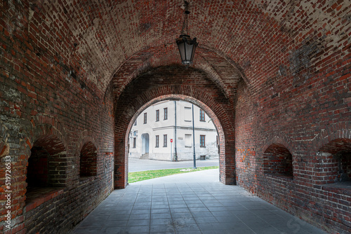 The interior of the Lviv Gate in Zamość. Brick barrel vault. Gate of a World Heritage City. An old lamp hanging on the vault. Zamość, Poland