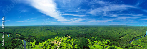 Panorama from height to summer forest, trees and river. Flying over the forest an river on bright sunny day
