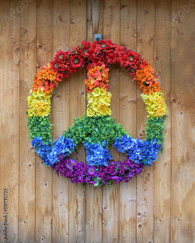 A colorful peace sign made of multi-colored flowers hangs on a wooden wall in Woodstock, NY. 