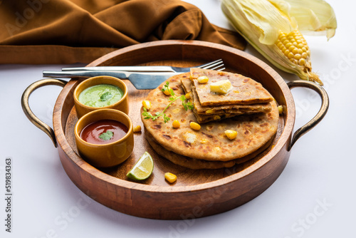 Sweet corn stuffed paratha or parotha served in a plate, Indian flatbread recipe made filling makai