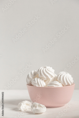 small white meringue in a deep pink plate on a white background