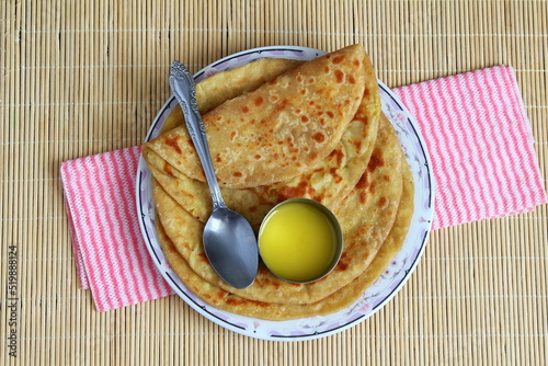 indian gujarati traditional sweet stuffed flatbread or sweet roti vedmi also known in india as holige,puran poli served with pure cows ghee clarified butter and papad