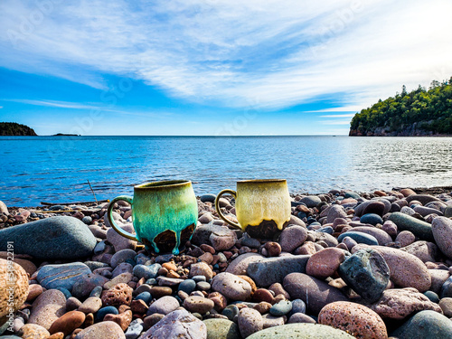 handmade pottery mugs enjoying rocky beach on north shore, Minnesota