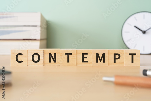 軽蔑・侮辱罪のイメージ｜「CONTEMPT」と書かれたブロックが置かれたデスク 