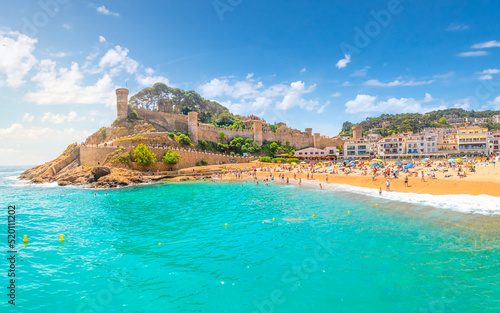 Panoramic view of the 12th century castle, the sandy beach, whitewashed town and turquoise waters of the Costa Brava coast along the Mediterranean Sea, at Tossa de Mar, Spain.