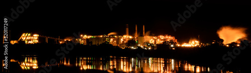 Panorama of an alumina refinery in Gladstone, Queensland, at night time with reflected lights.