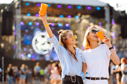 Two young woman with beer at beach party. Summer holiday, vacation concept. Friendship and celebration concept.