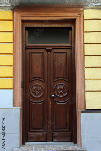 Entrance of house with beautiful wooden door and transom window