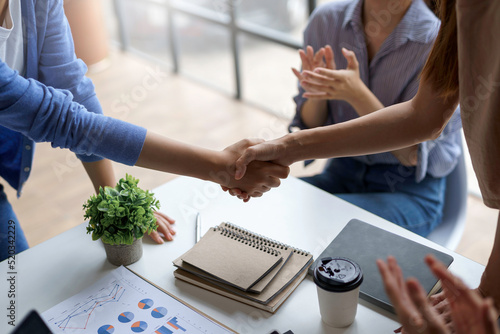 A group of Asian business people handshake to make a contract business agreement to start a new business.