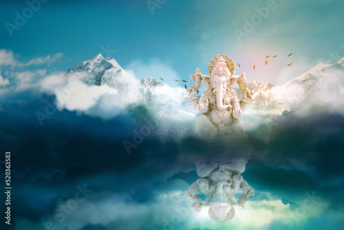 Lord ganesha sculpture on mountain and sky background.