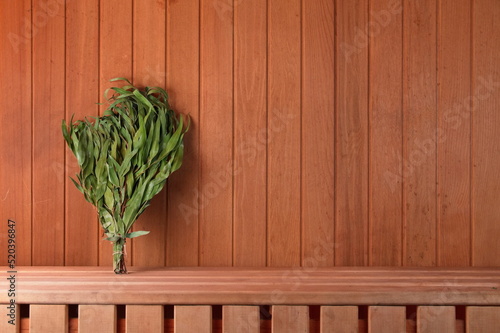 Dry eucalyptus broom on a wooden shelf in the sauna. Horizontal Photo for Design