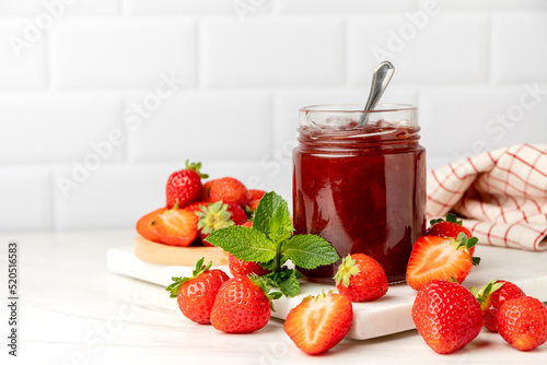 Homemade strawberry jam in glass jar and fresh strawberries 