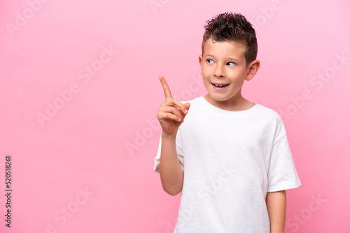 Little caucasian boy isolated on pink background intending to realizes the solution while lifting a finger up