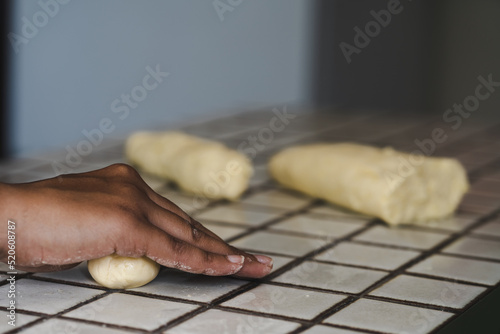 Woman hands rolling dough for making chipa, paraguayan cheese-flavored rolls