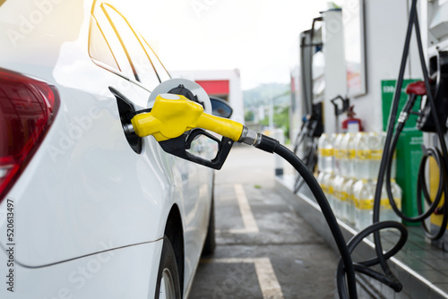 Transportation and ownership concept - man pumping gasoline fuel in car at gas station. hight price during war concept.