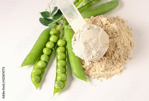 Plant base protein Pea Protein Powder in plastic scoop with fresh green Peas seeds on white Background, isolated copy space. 