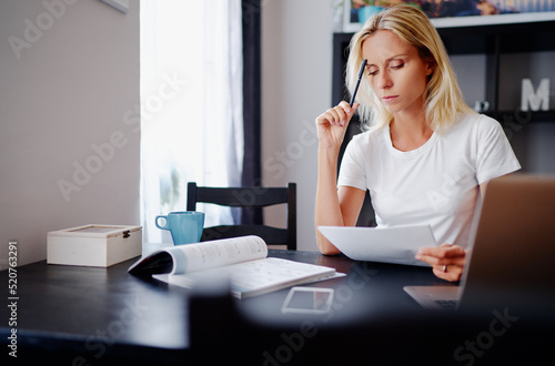 Ideas for business. Studying and working at home. Freelance concept. Thoughtful young woman making notes using laptop.