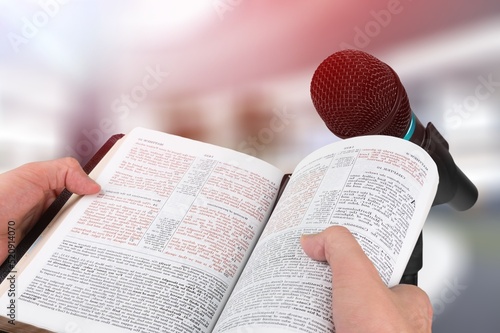 Pastor with a Bible in hand during a sermon. The preacher delivers a speech