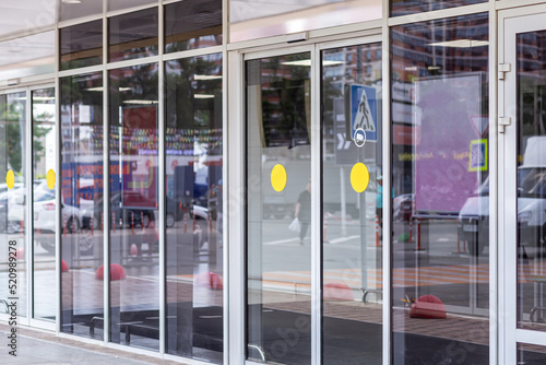 Supermarket automatic glass doors with camera sign closeup