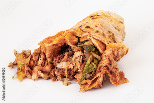 Isolated on a white background, spoiled and greasy and unhealthy doner or shawarma. Harmful and dangerous fast and street food